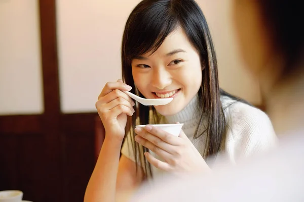 Mujer joven sosteniendo un tazón, comiendo sopa — Foto de Stock