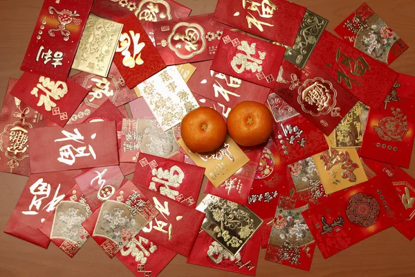 Red envelopes with oranges — Stock Photo, Image