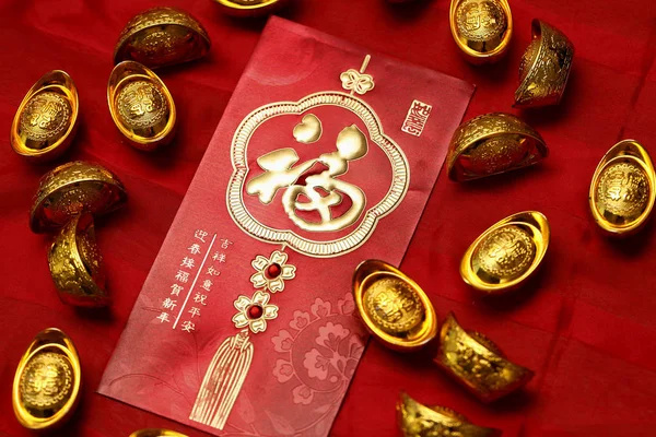 Gold ingots on red envelopes — Stock Photo, Image