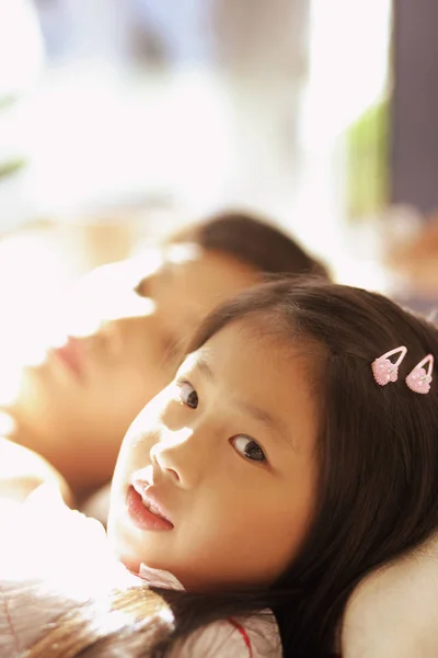 Mladá dívka ležící vedle její matka — Stock fotografie