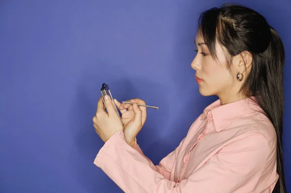 Woman, using PDA, side view Stock Photo