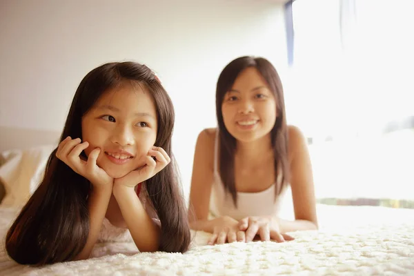 Madre e hija acostadas en la cama — Foto de Stock