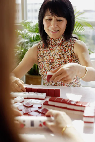 Frau mit Mahjong-Fliese — Stockfoto
