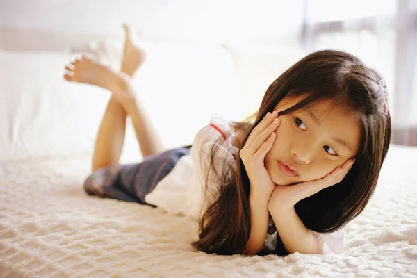 Dívka ležící na posteli — Stock fotografie
