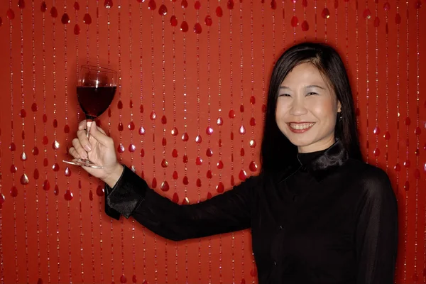 Frau hält Glas Wein in die Höhe — Stockfoto