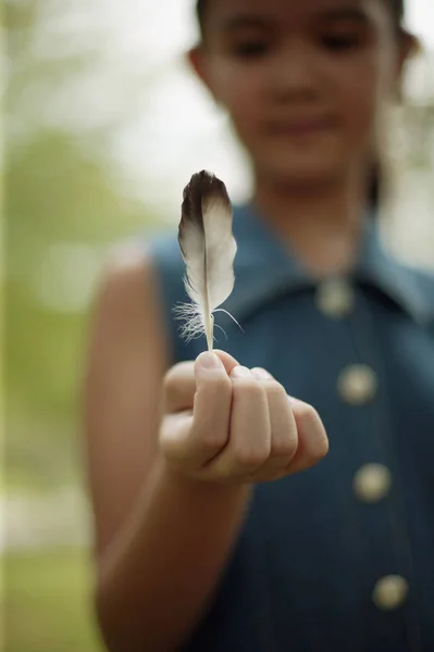 Niña sosteniendo una pluma — Foto de Stock