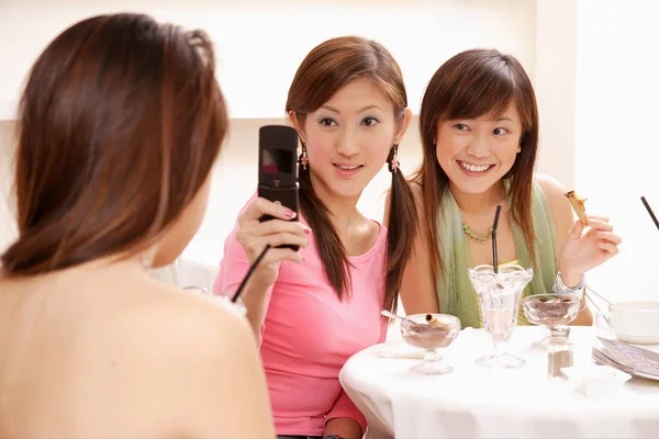 Mulheres segurando telefone câmera — Fotografia de Stock