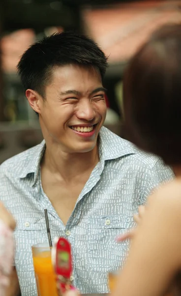 Joven hombre sonriendo, mujer en primer plano — Foto de Stock