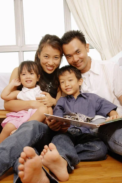 Familie mit zwei Kindern sitzt zusammen — Stockfoto