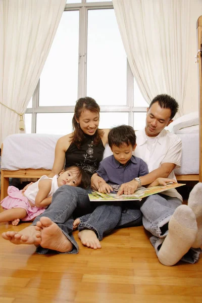 Padres leyendo con hijo — Foto de Stock