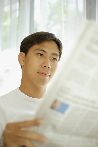 Young man reading newspaper
