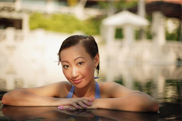 Mujer joven en el borde de una piscina — Foto de Stock