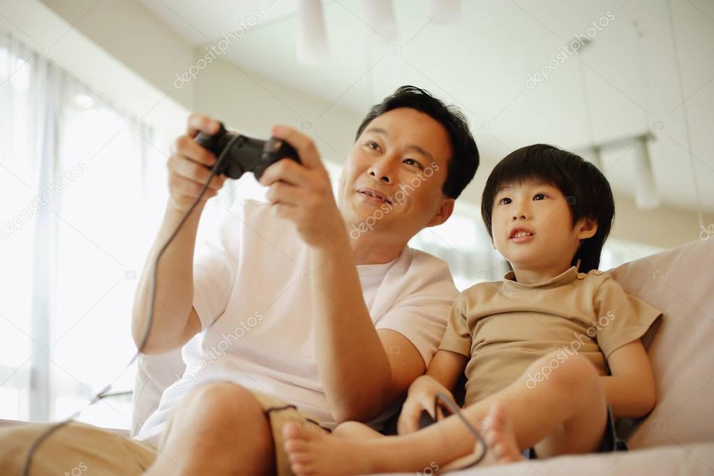 Father and son sitting on sofa 