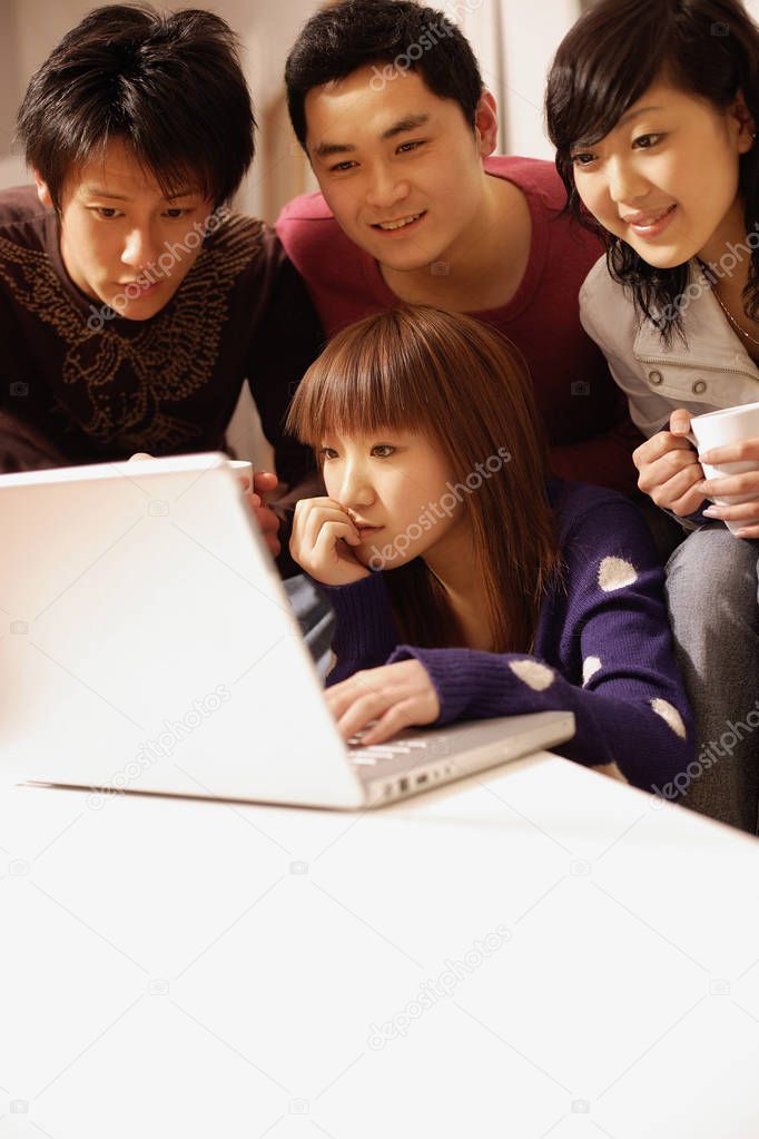 Friends sitting around laptop