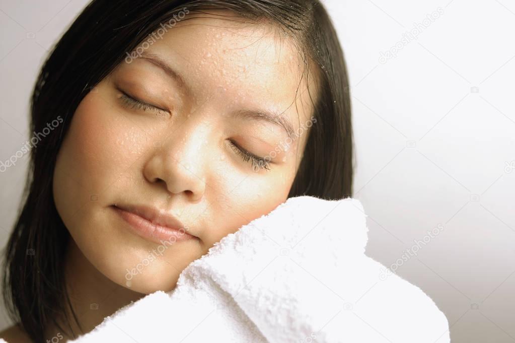 woman wiping her face with towel