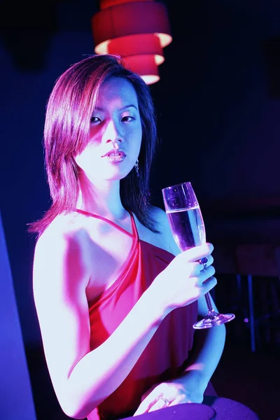 Молодая женщина поднимает бокал вина — стоковое фото
