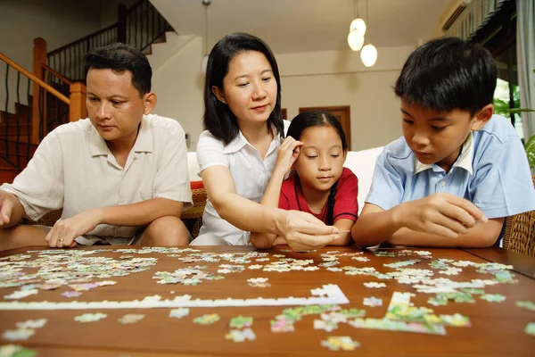 Family in living room, sitting side by side