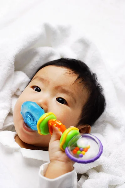 Младенец кусающий игрушку — стоковое фото