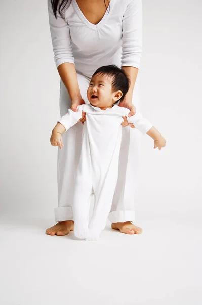 Bebé niño de pie con madre — Foto de Stock