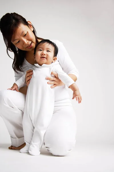 Bebé niño de pie con madre — Foto de Stock