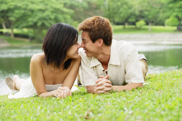 Par som ligger på gräs — Stockfoto