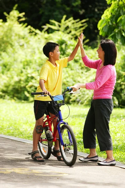 Madre guiando hijo en bicicleta — Foto de Stock