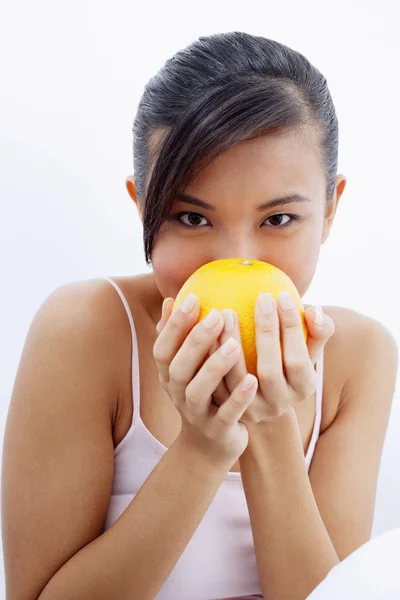 Mulher a cheirar laranja — Fotografia de Stock