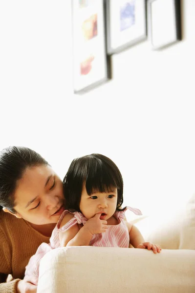 Madre con la niña, en el sofá — Foto de Stock