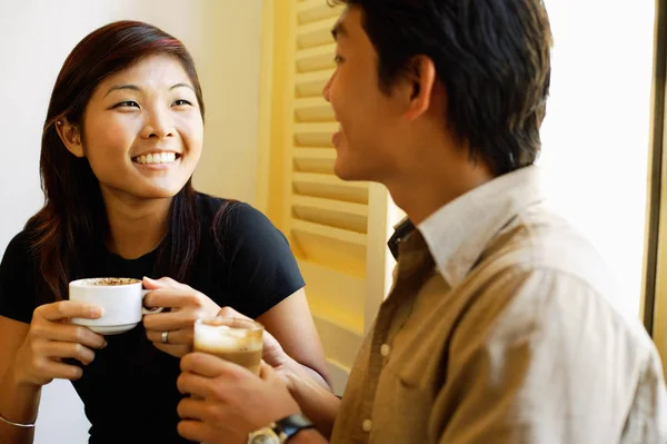 Couple at cafe with cups of coffee — Stock Photo, Image