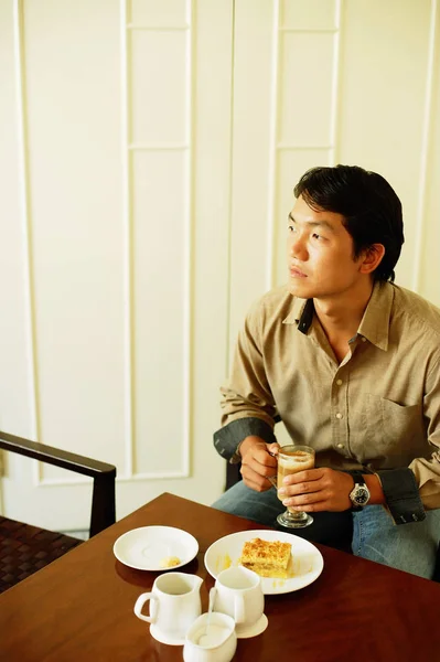 Молодой человек держит кофе — стоковое фото