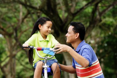 Onun yanında çömelmiş kız babası