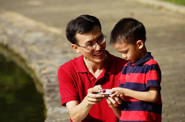 Father and son looking at control — Stock Photo, Image