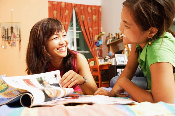 Madre con figlia guardando la rivista — Foto Stock