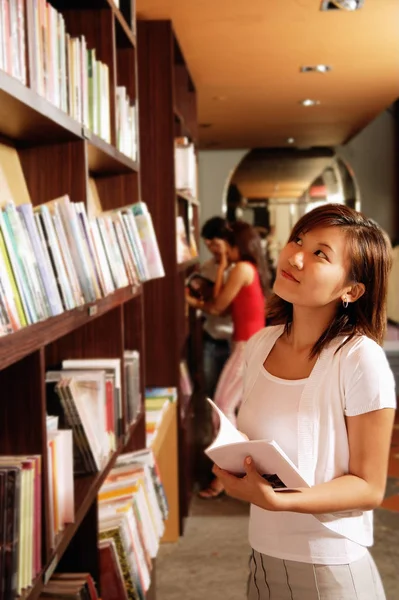 Jeune femme à la librairie — Photo