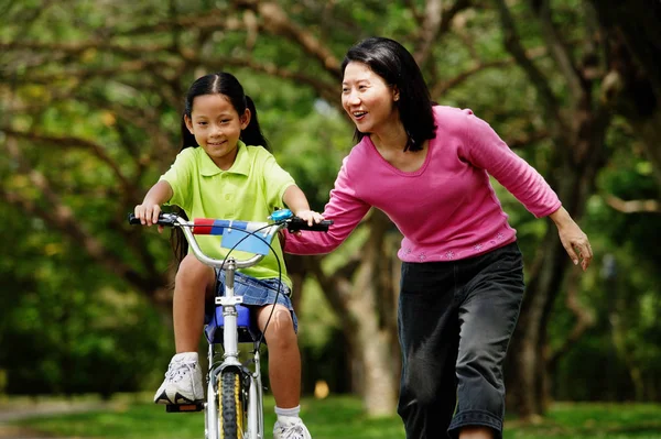 Fata cu bicicleta, mama lângă ea — Fotografie, imagine de stoc