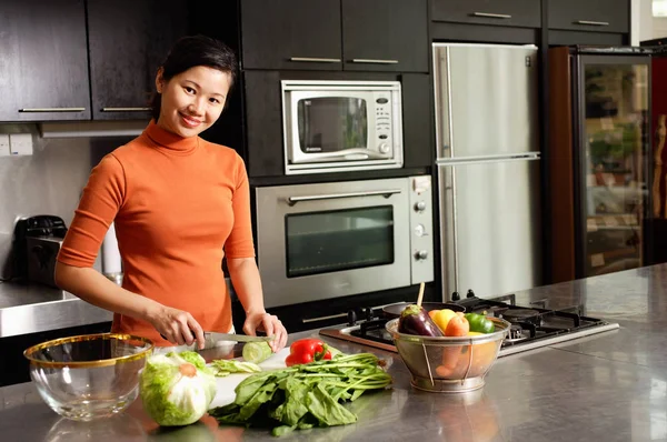 Femme coupe des légumes dans la cuisine, — Photo