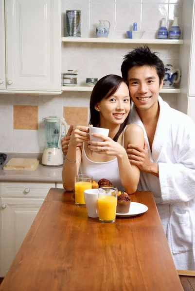 Casal na cozinha sorrindo para a câmera — Fotografia de Stock