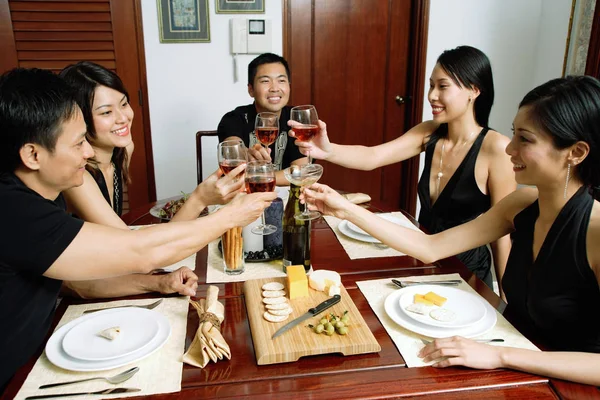 Adultos sentados à mesa de jantar — Fotografia de Stock