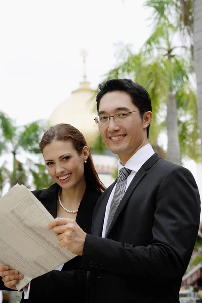 Empresario y empresaria con periódico — Foto de Stock