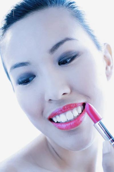Wanita muda menerapkan lipstik — Stok Foto