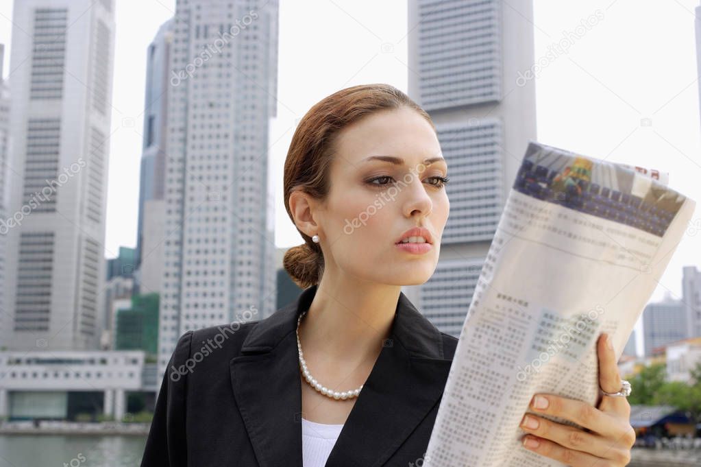 Businesswoman reading newspaper