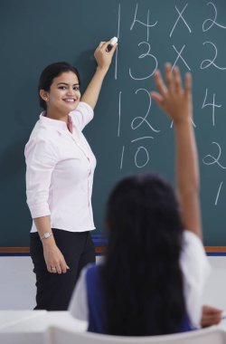 Kara tahta ve kız öğretmen el yükseltir