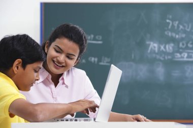 öğretmen ile öğrenci laptop çalışma