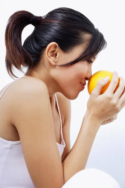 Woman smelling orange — Stock Photo, Image