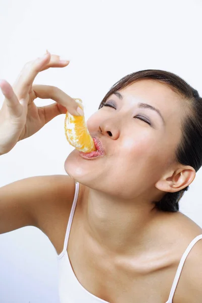 Kobieta jedzenie pomarańczy — Zdjęcie stockowe