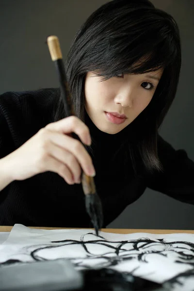 Girl writing Chinese calligraphy