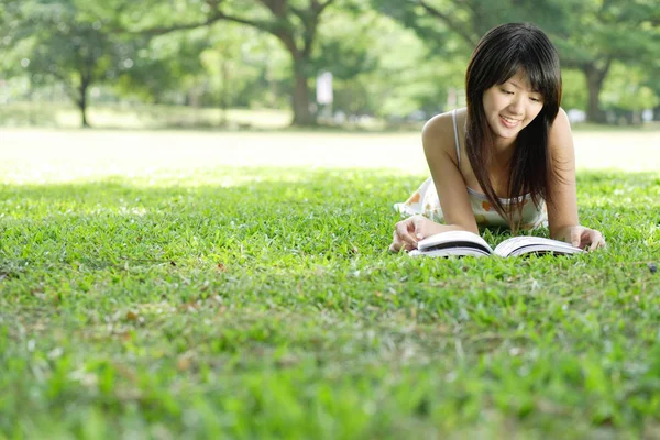 Jeune femme avec magazine dans le parc — Photo