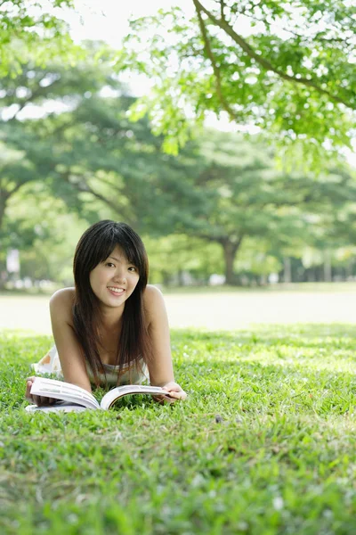 Jeune femme avec magazine dans le parc — Photo