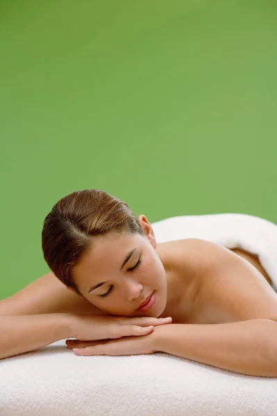 Mulher deitada na mesa de massagem — Fotografia de Stock