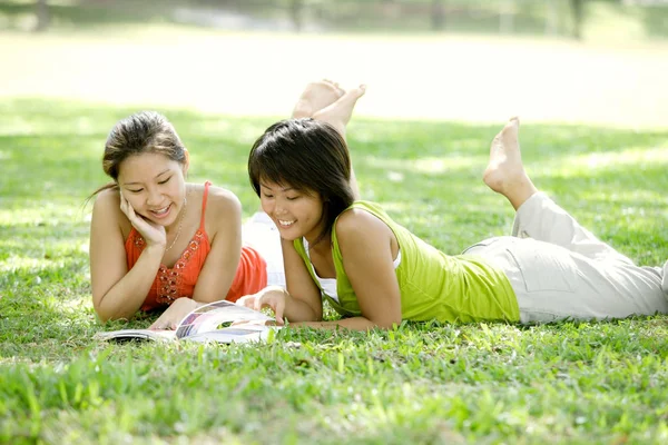 Jonge vrouwen liggen op gras — Stockfoto
